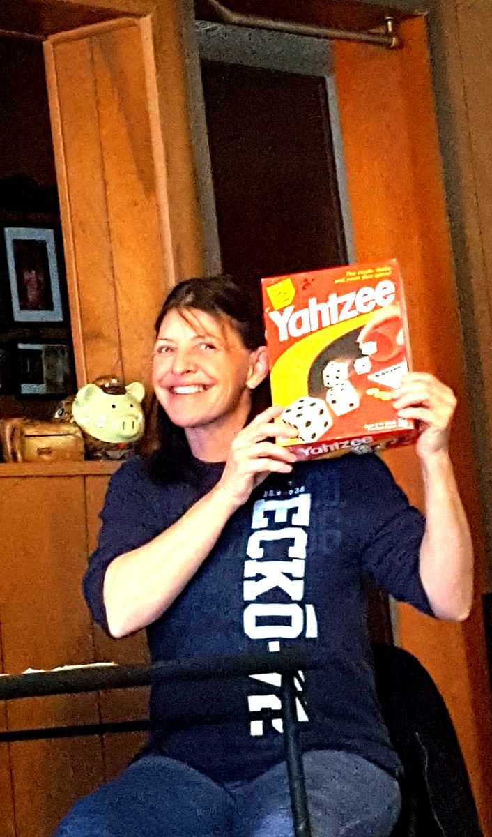Kellie, founder of Kellie's Corner Thrift & Boutique, holding a Yahtzee game